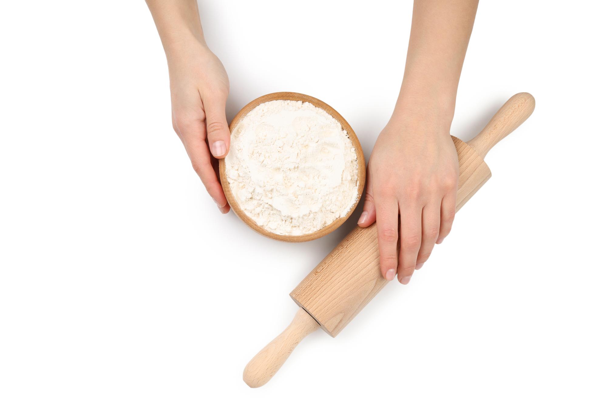 Hands kneading dough on a floured board